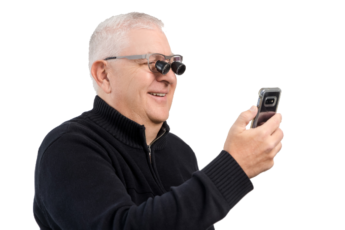 A man wearing bioptic telescopes looking at a phone
