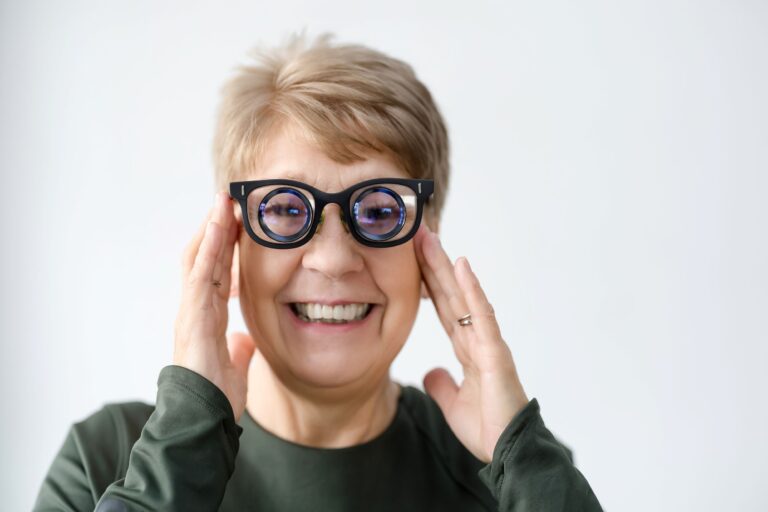 A woman wearing low vision glasses smiling